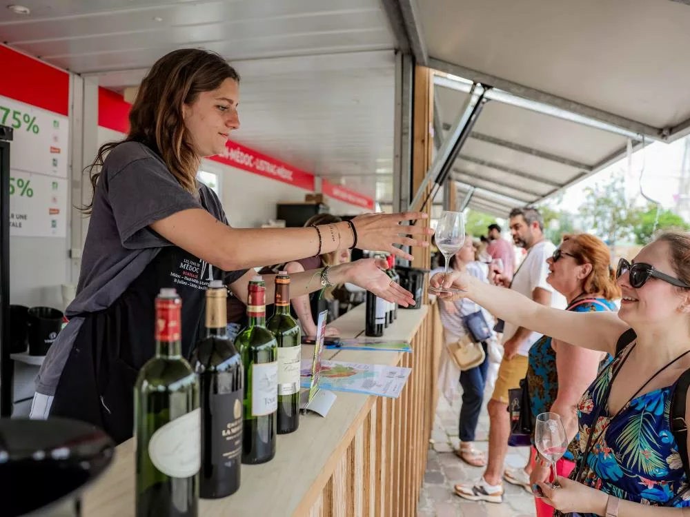 vigneronne opératrice sur bordeaux fête le vin qui donne un verre de vin à déguster à une visiteuse