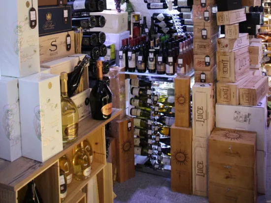 magasin type caviste avec des bouteilles et cartons du sol au plafond