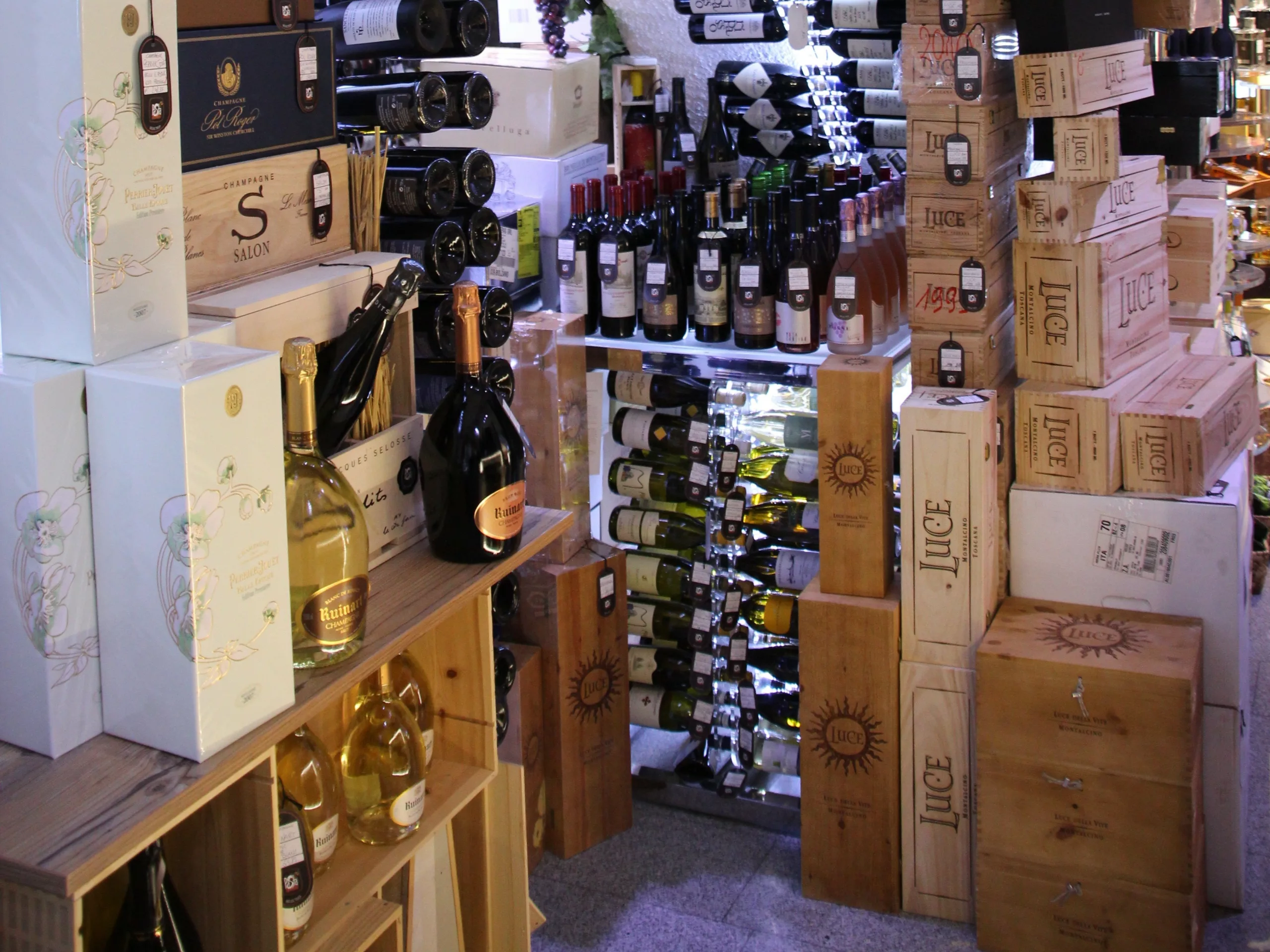 magasin type caviste avec des bouteilles et cartons du sol au plafond