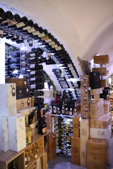 magasin type caviste avec des bouteilles et cartons du sol au plafond