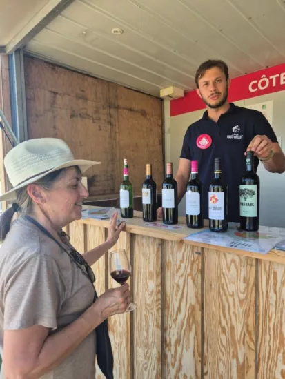 William Delanoë du Château Haut-Grelot présente ses vins sur son stand à une visiteuse de Bordeaux Fête le Vin