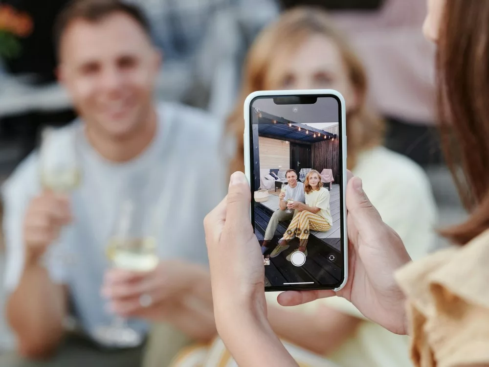 une femme prend en photo un couple d'influenceur avec son téléphone