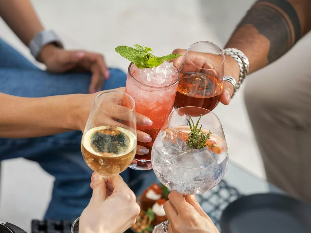 mains tenant des verres de vins, spiritueux et cocktails pour trinquer